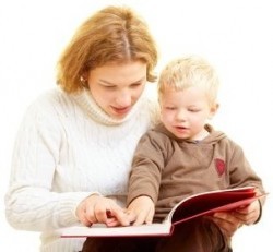 Mutter liest ihrem Kleinkind aus einem Buch vor