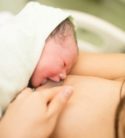 Neugeborenes an der Brust der Mutter