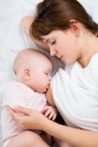 Mutter und Baby stillen nachts im Bett
