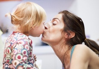 Lippenkuss zwischen Mutter und Tochter