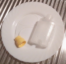 Milchbehälter und Schläuche des Brusternährungssets auf einem Teller